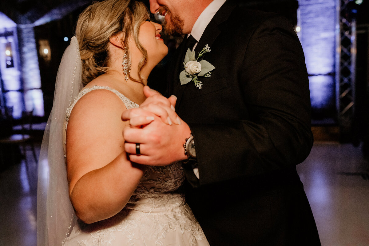 detail shot of bride and grooms hands holding one another during their first dance as husband and wife during their wedding reception