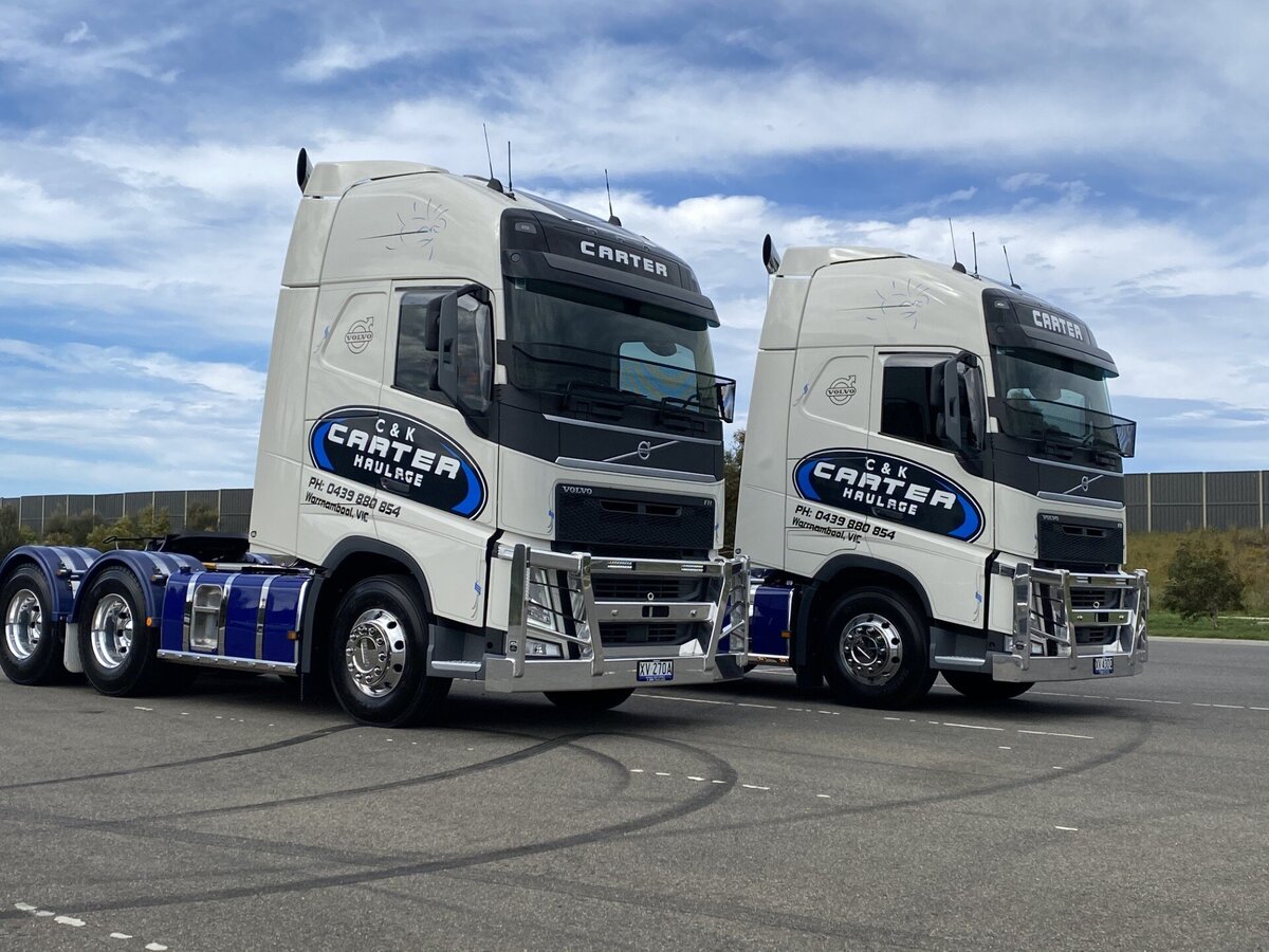 Two trucks ready to pick up their next load to be transported.