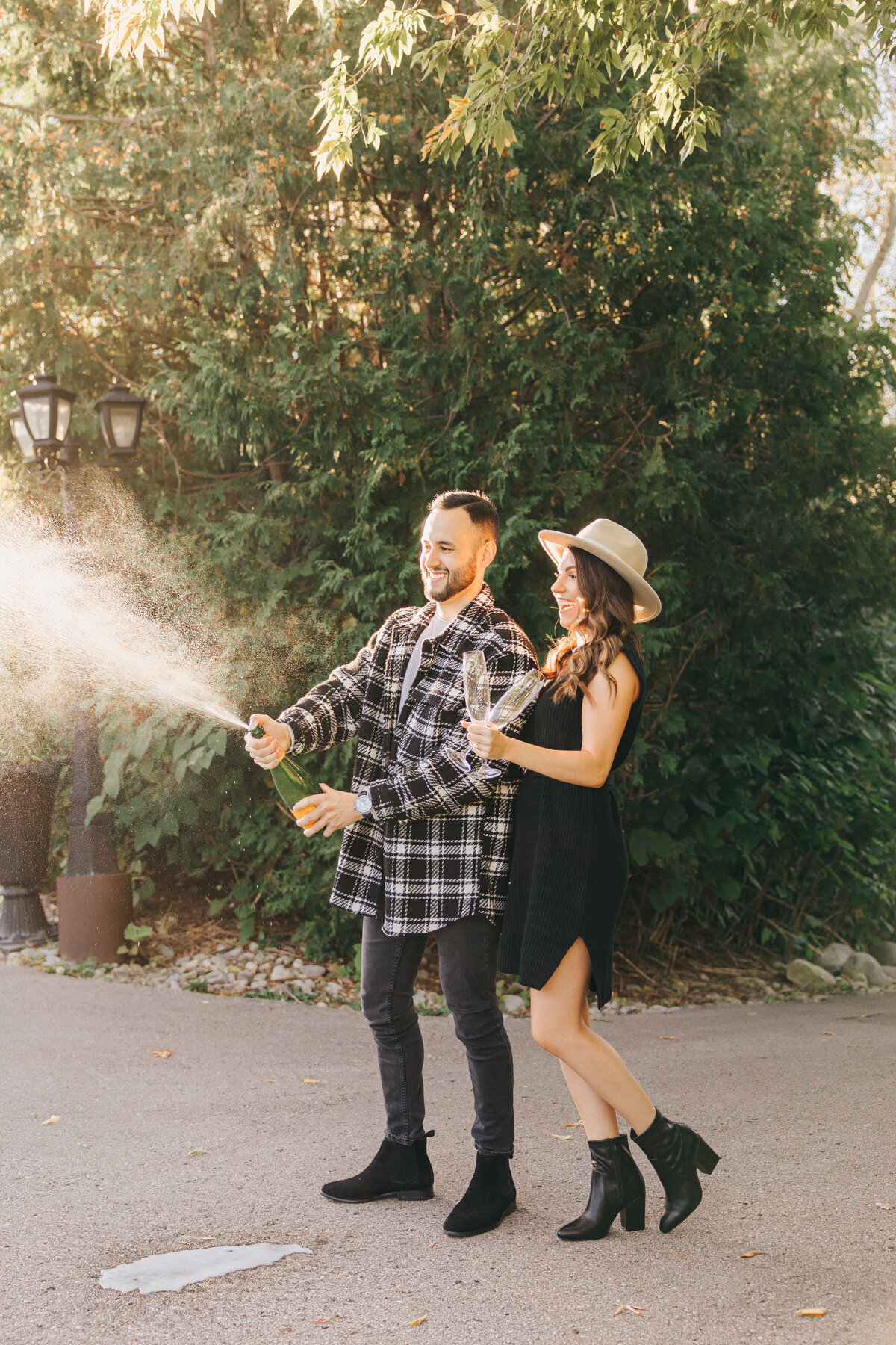 Couple popping champaign at their Elm Hurst Engagement Session by NovaMarkina Photography