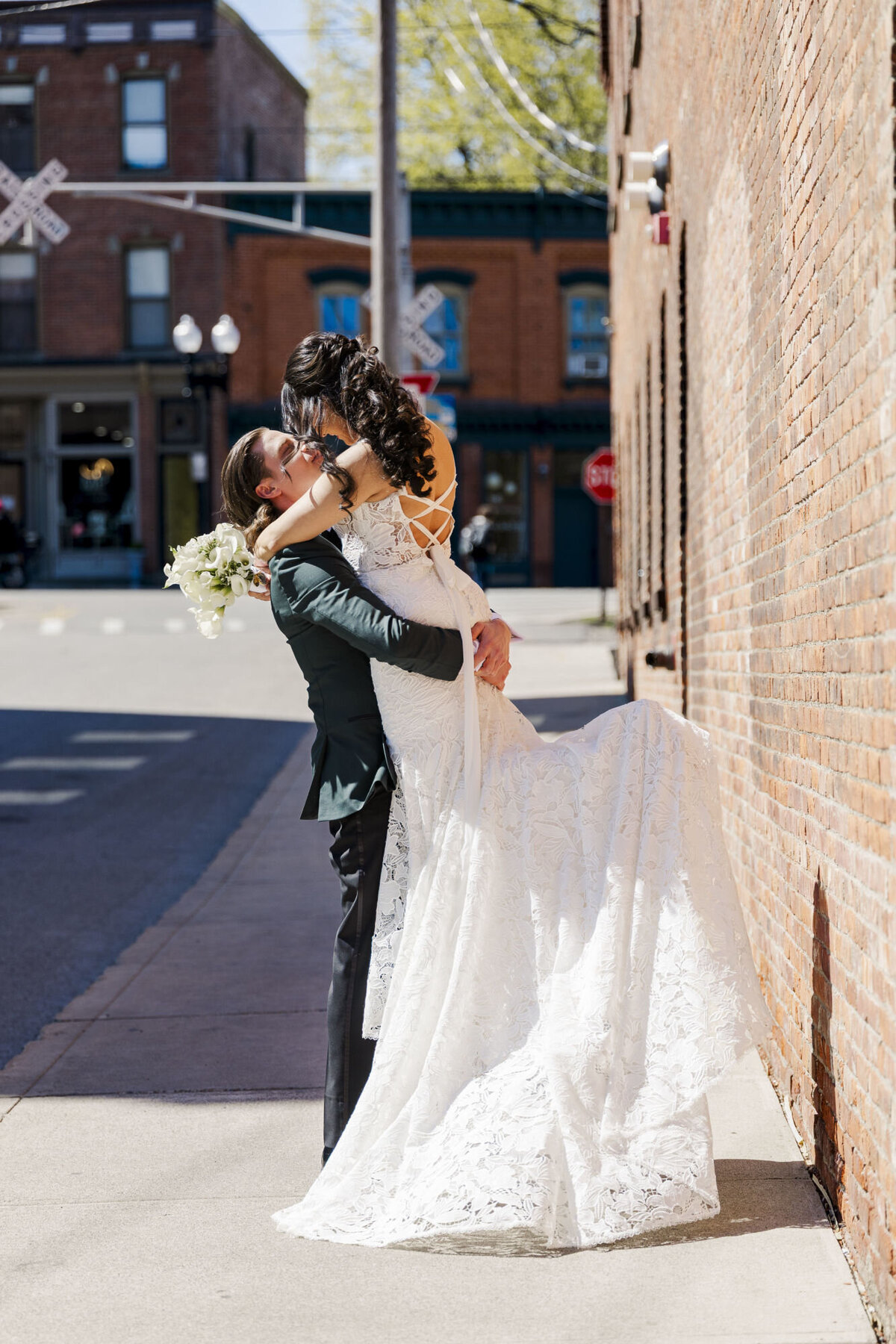The groom scoops up the bride on Main Street in Beacon, NY for their wedding at The Roundhouse