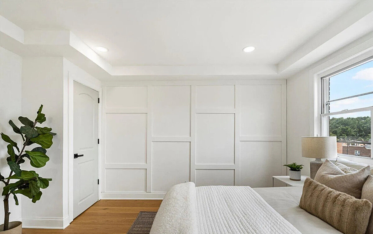 Modern bedroom remodel featuring custom wall paneling, wide-plank hardwood floors, and natural light—crafted to create a serene and stylish retreat.
