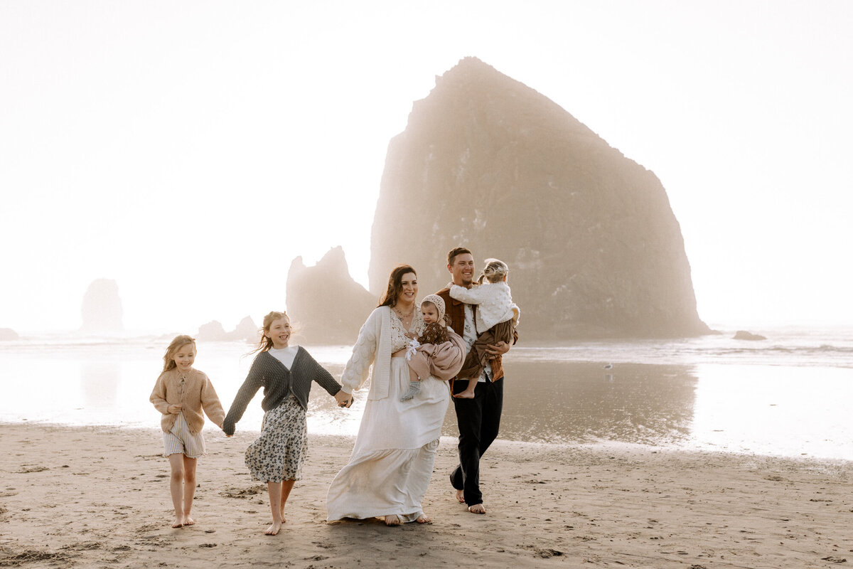 family walking on a beach holding hands
