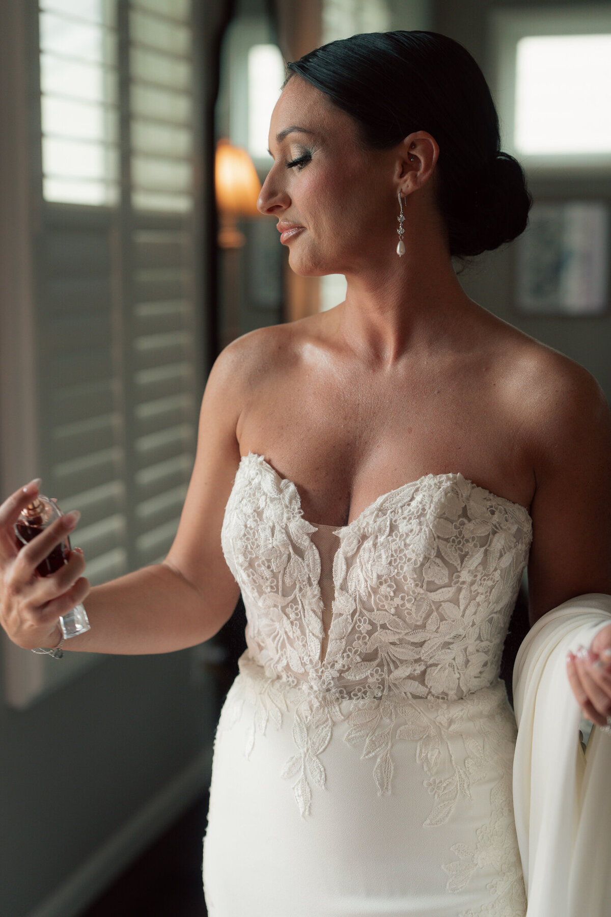 Bride spraying perfume while getting ready in bridal suite