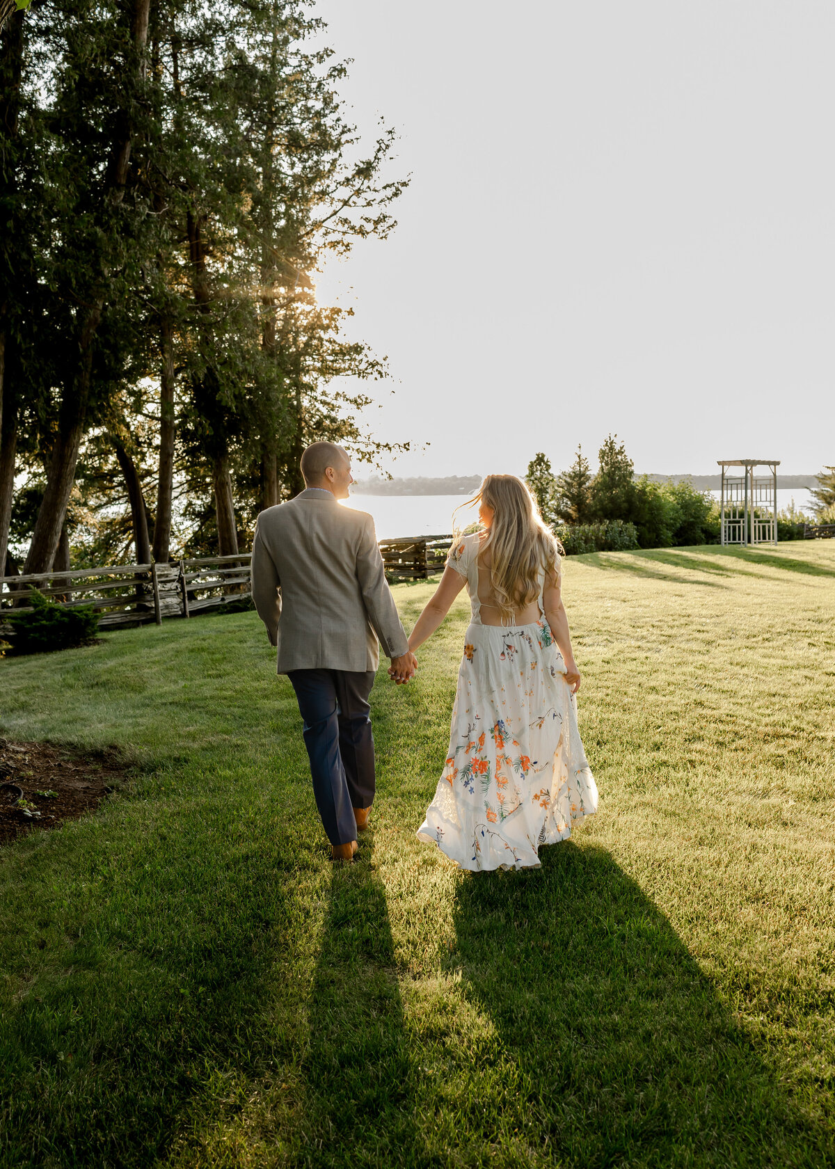 on the shores of lake champlain at the ferry watch inn a bride and groom walk hand in hand after saying i do 
