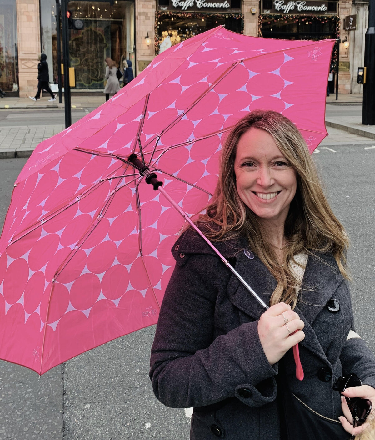 Terra Brown from Adventures by Terra standing with a pink polkadot umbrella in London, England