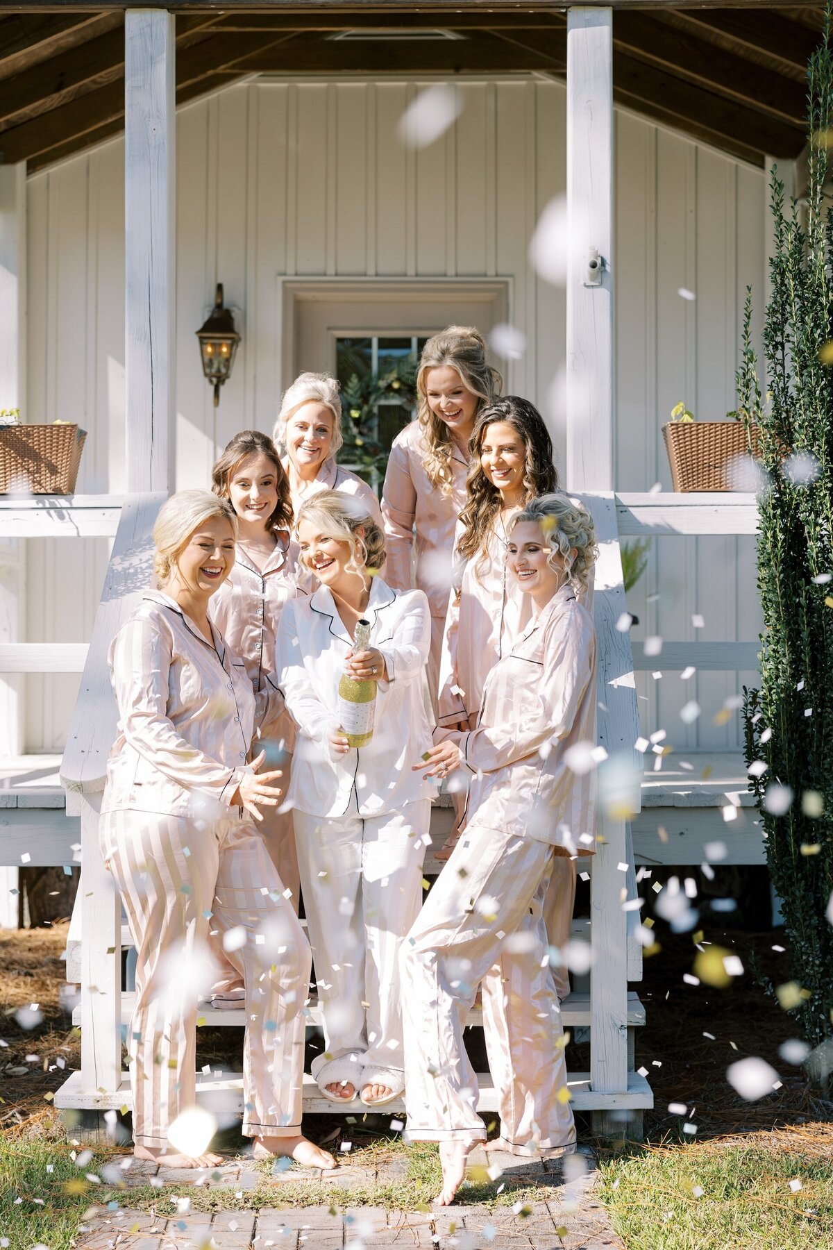 bride and bridesmaids celebrating the start of wedding day by popping confetti
