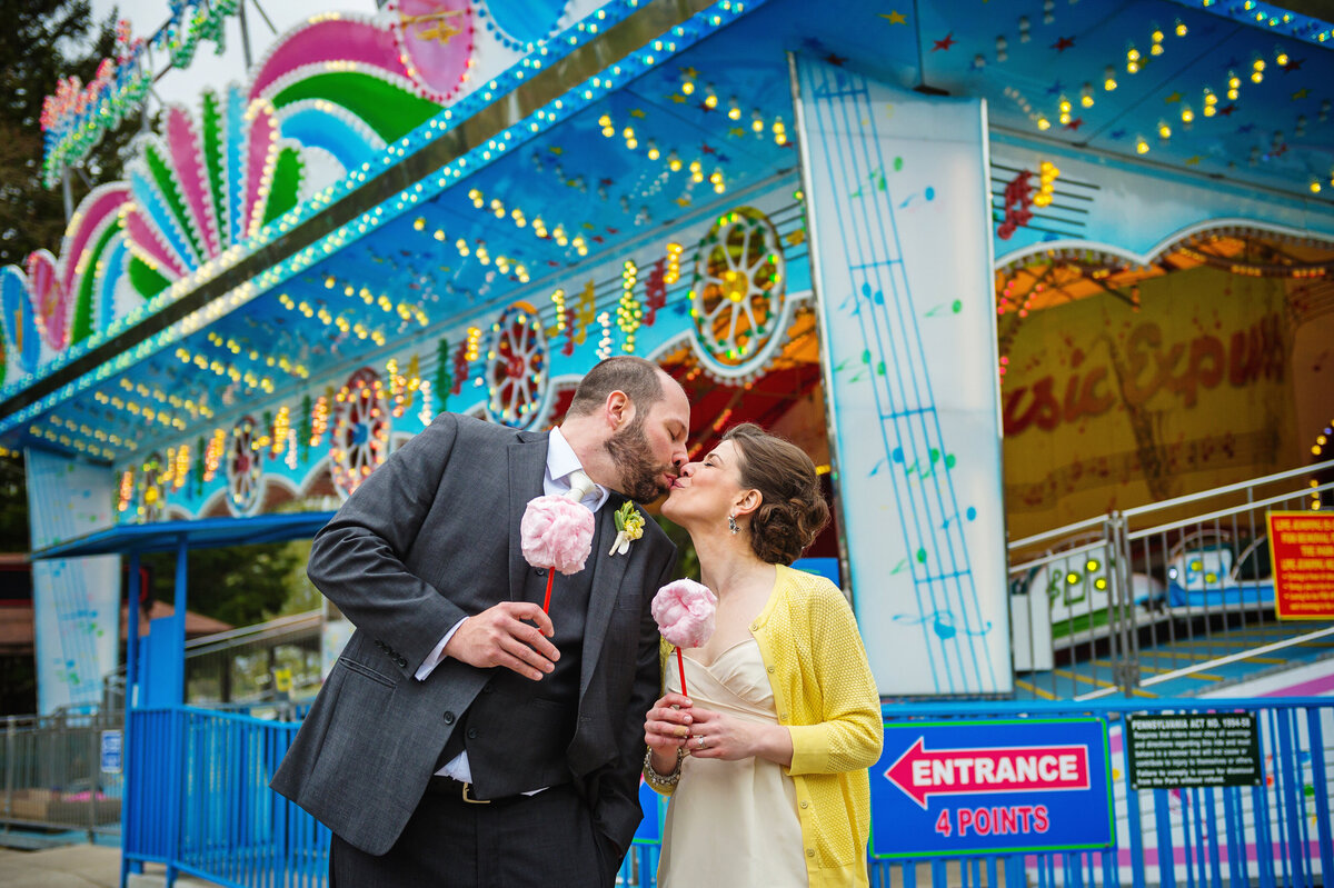 Wedding couple kissing and eating cotton candy at Waldameer.