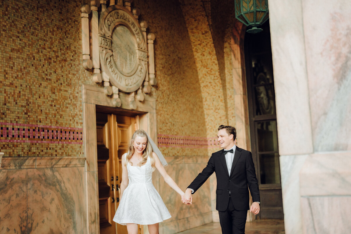 Bride and groom walking hand in hand laughing, taken by Asheville Wedding Photographer Simon Anthony Photography