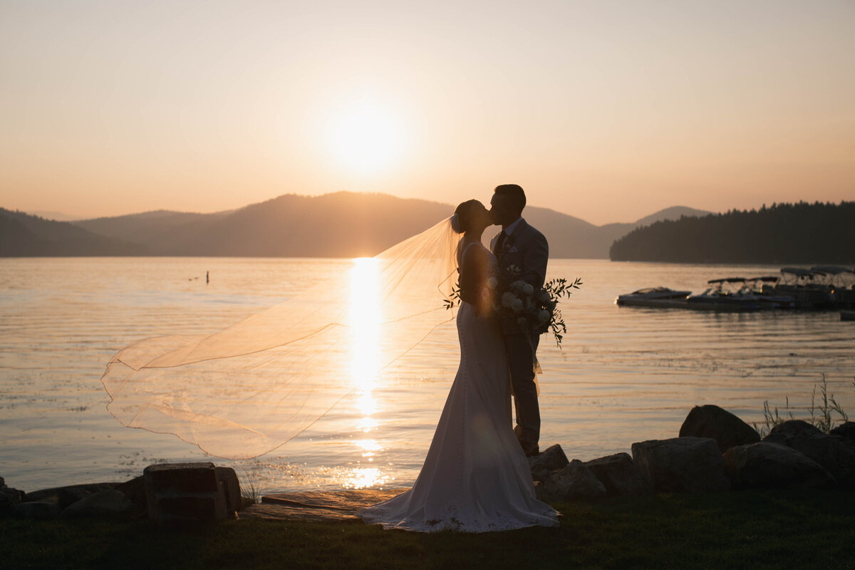 bride and groom kissing at sunset