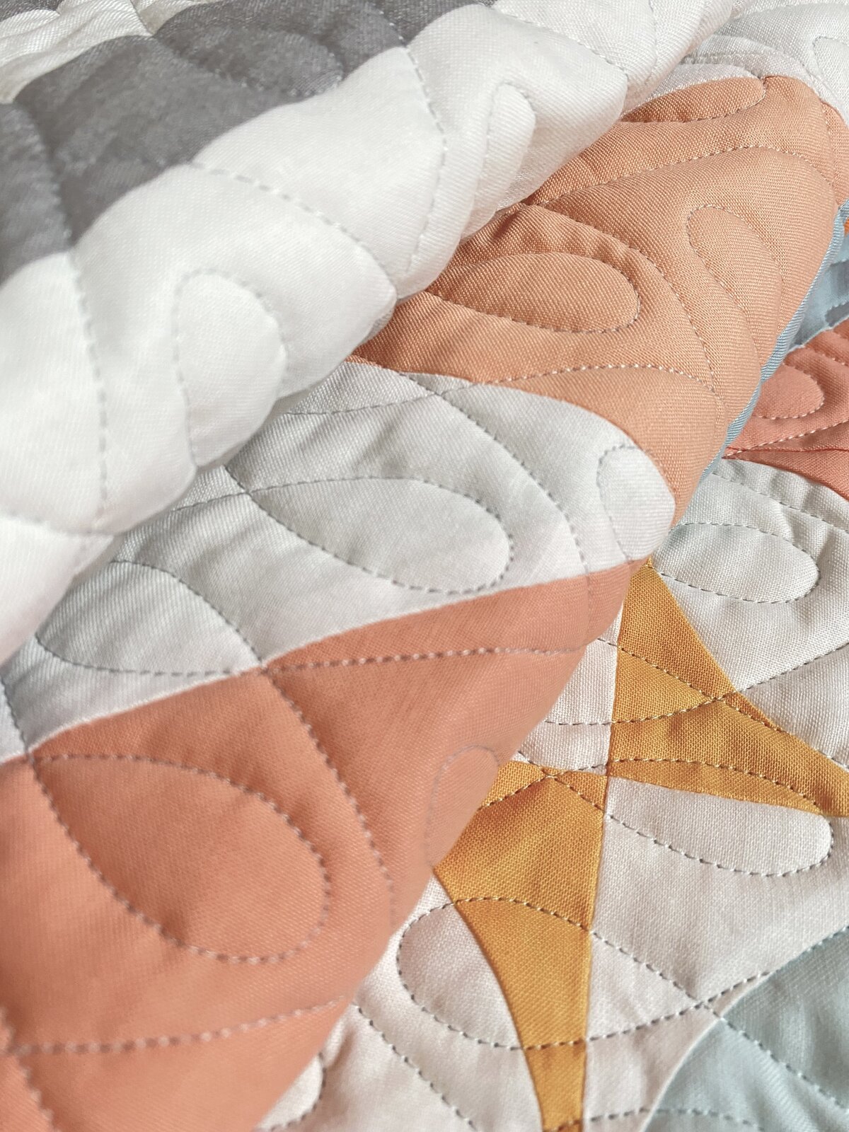 the crazy 8s quilting design on a peach and white quilt