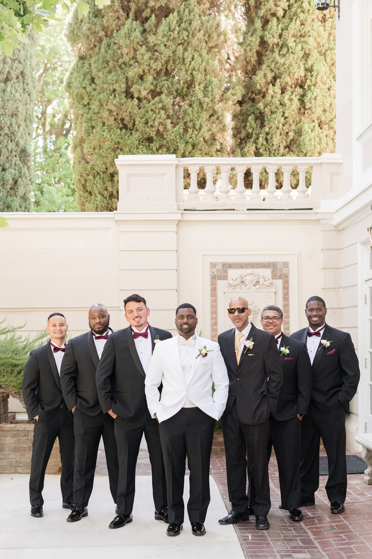 groom and groomsmen standing posing for the camera