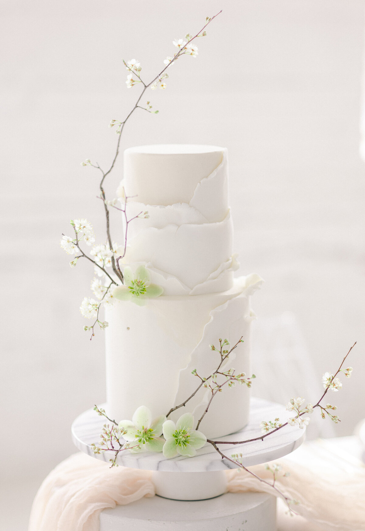 Minimalist greenery decorating an elegant wedding cake in Montreal.