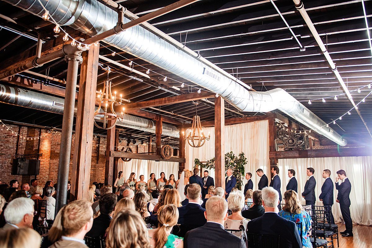 Full view of Cannery ONE ceremony with guests seated and wedding party at arbor