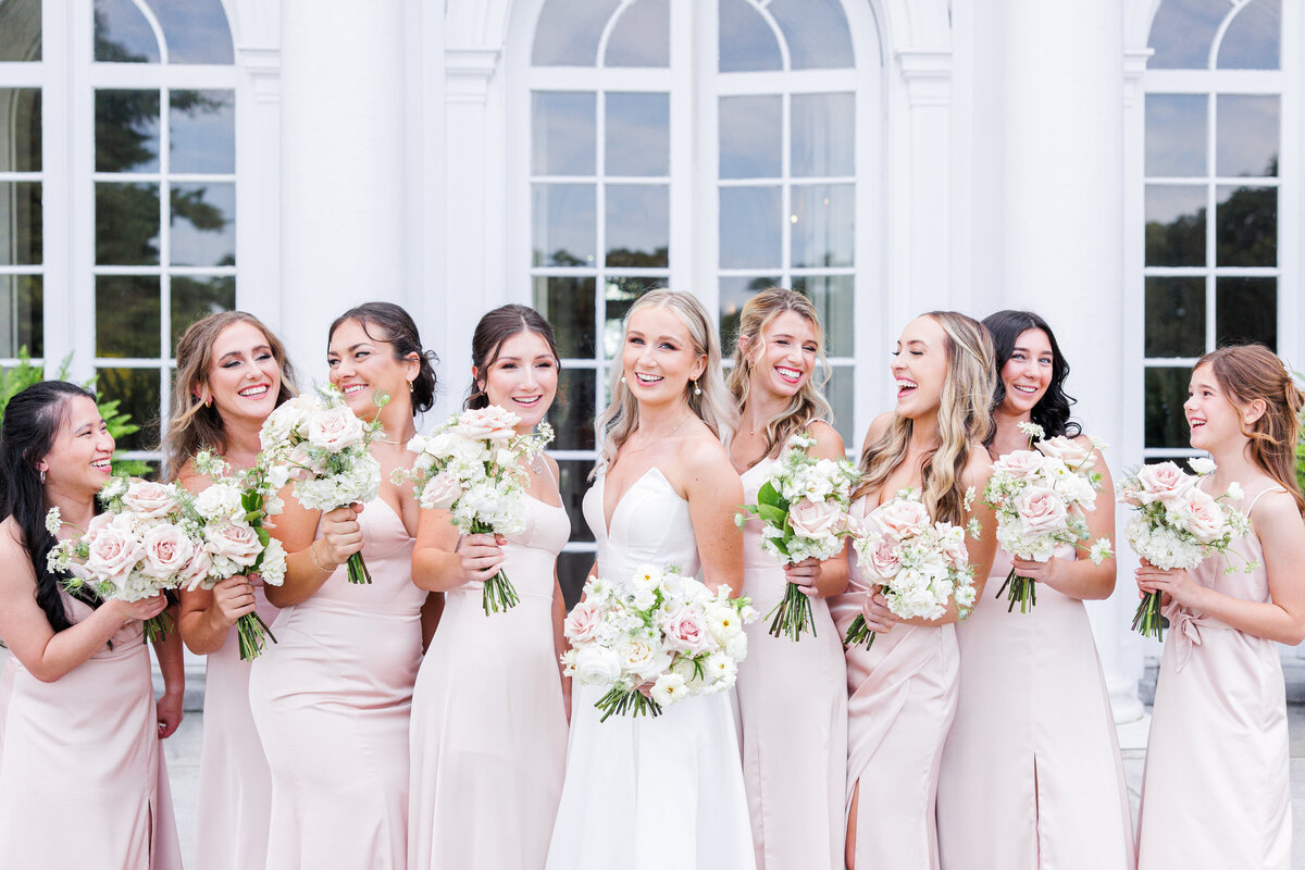 Group of bridesmaids with the bride in the middle laughing representing joyful Boston wedding photography