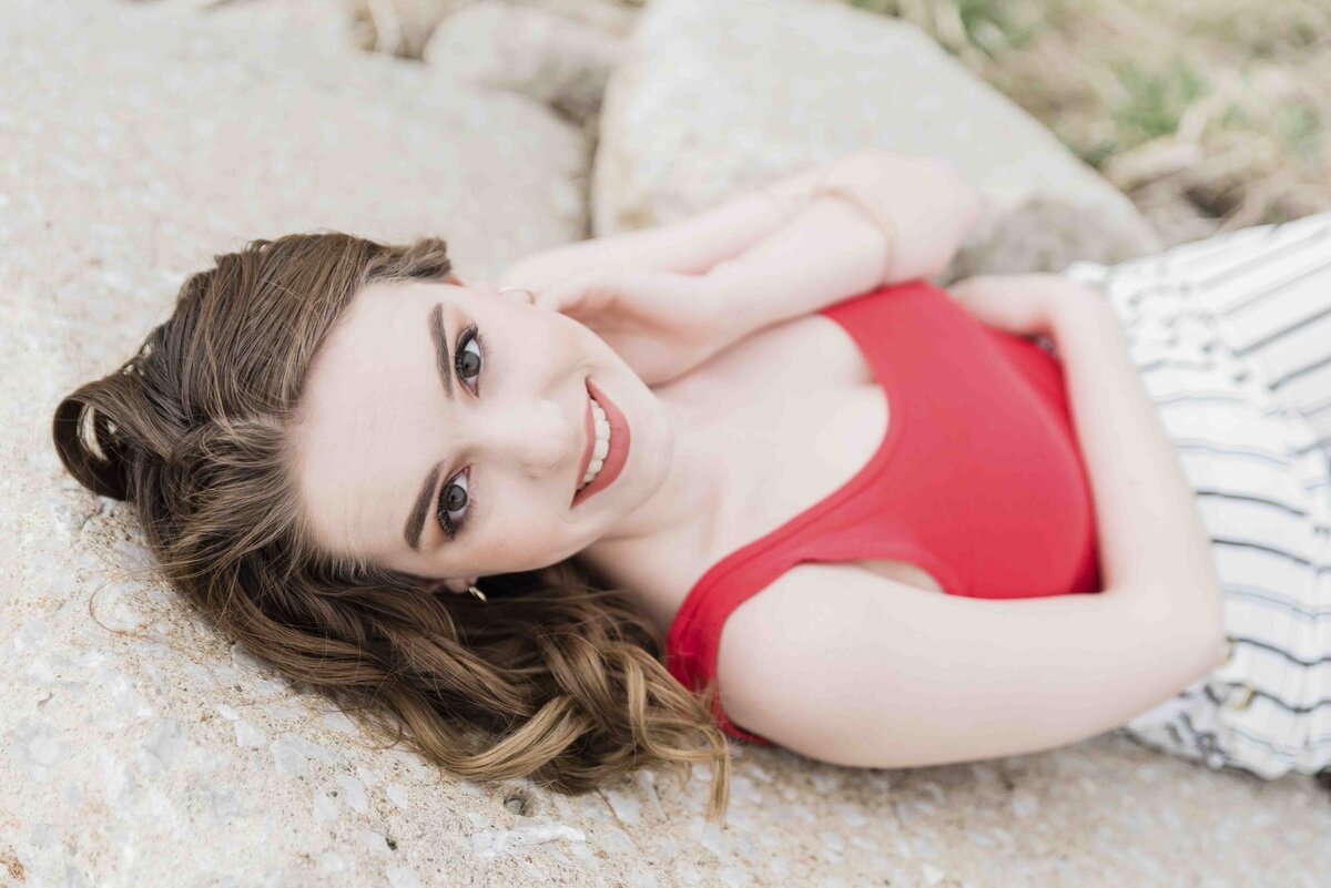 Senior girl laying on rocks smiling