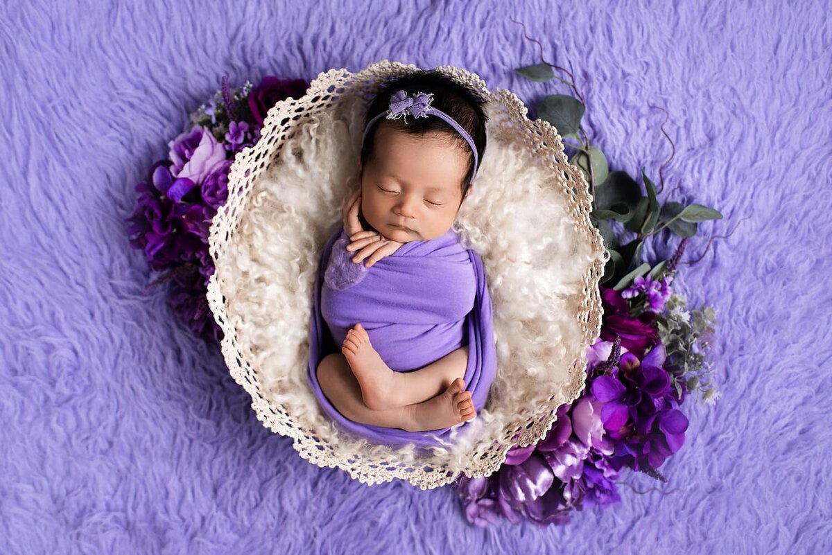 mobile-in-home-newborn-photography-vancouver-fraser-valley_baby-girl-wrapped-lilac-basket-flowers