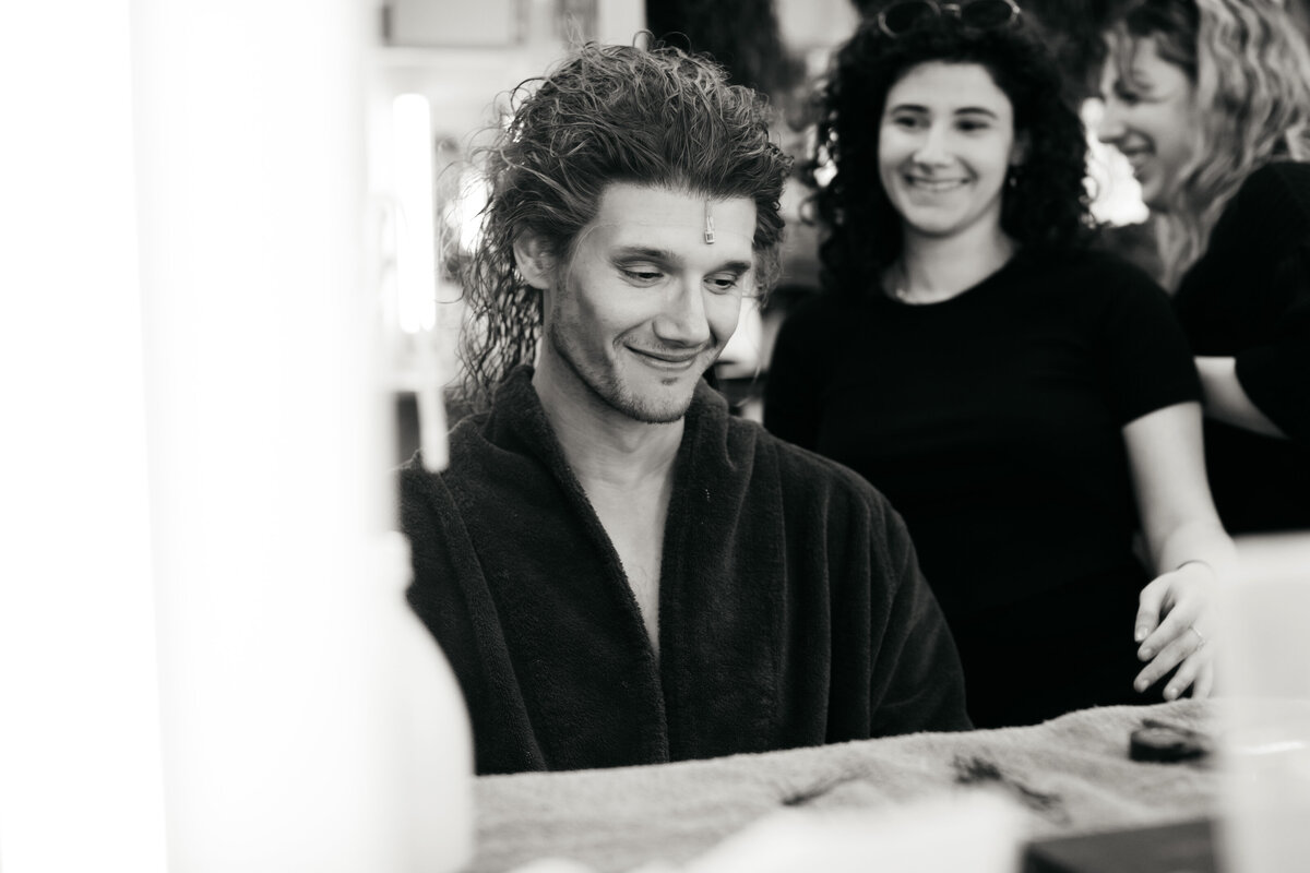 Backstage portret van acteur met pruik op en microfoon op voorhoofd.