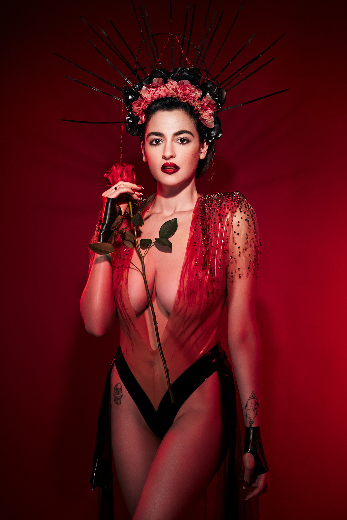 Glamorous portrait of Hanna Cruz in a red floral outfit with bold makeup, shot by Ylva Erevall.
