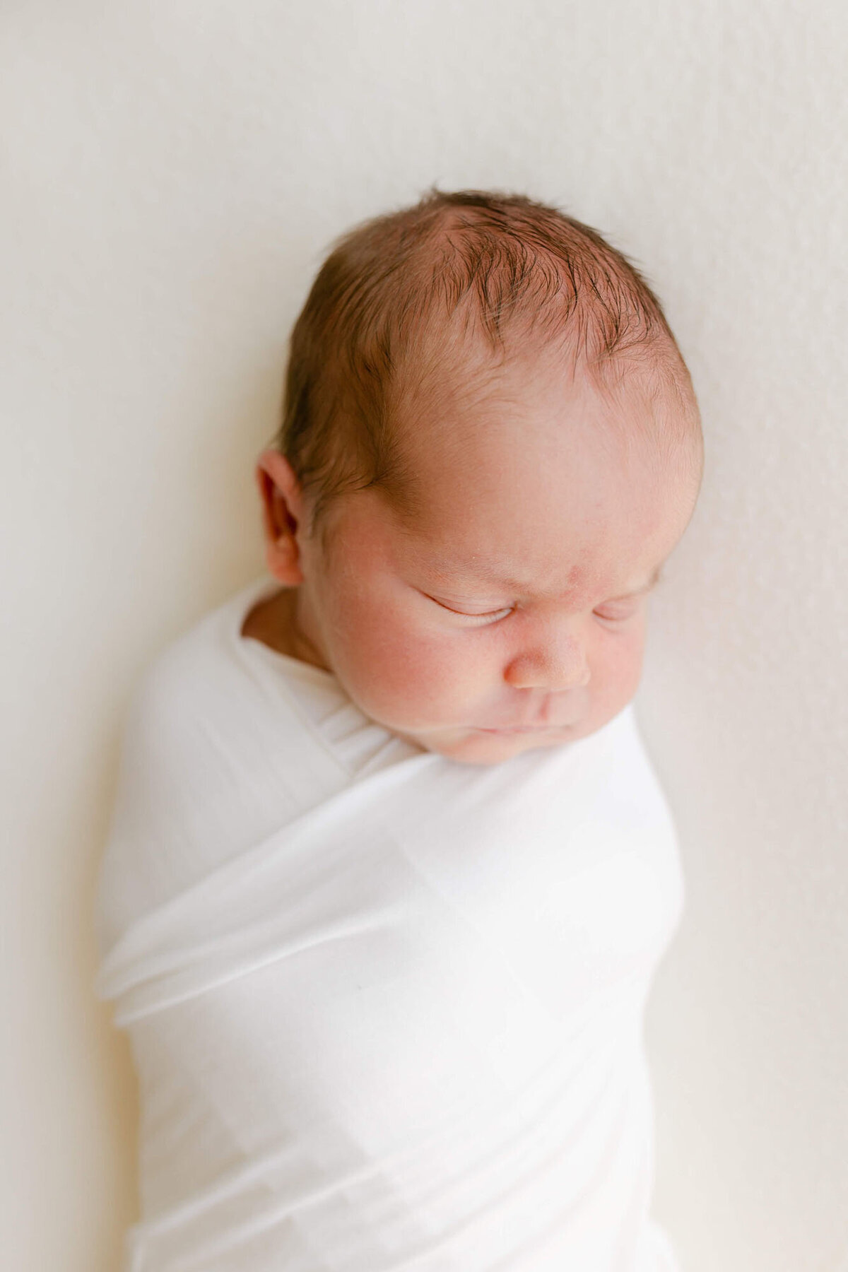 Tender moment of parents and baby in bedroom, Bay Area newborn family photography.