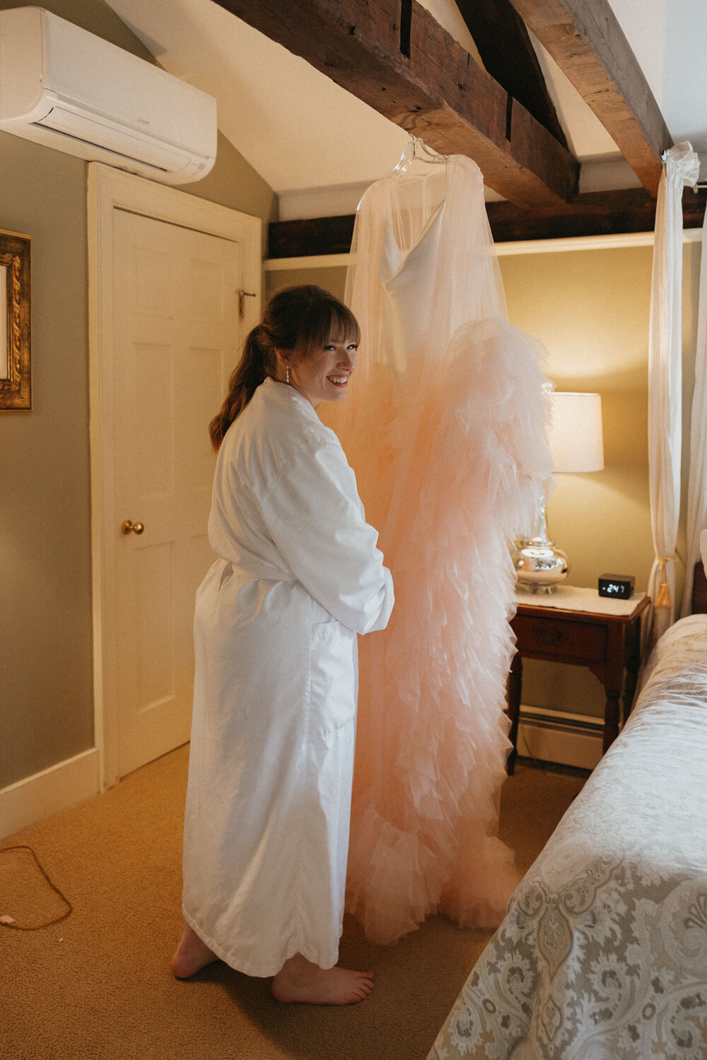 Bride happily preparing to wear her pink robe