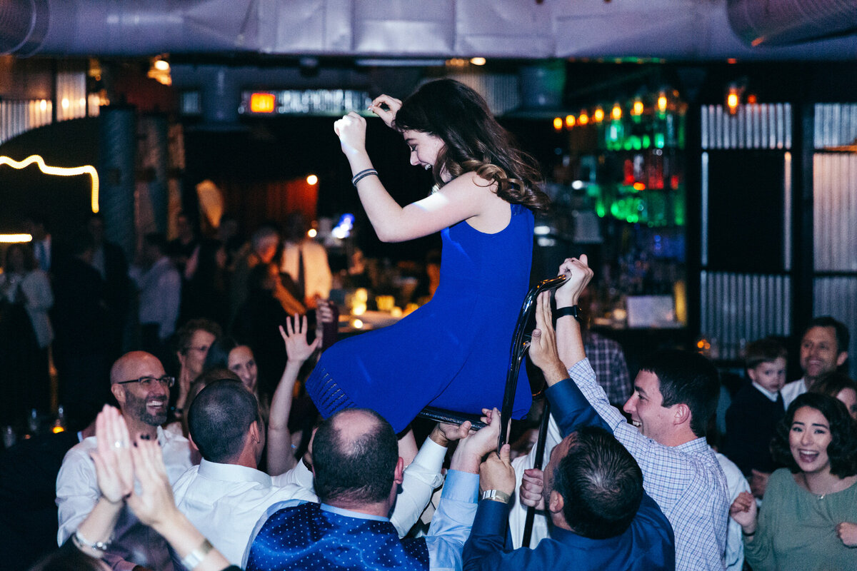 Bat mitzvah girl being raised in chair by family and friends in Northern Virginia