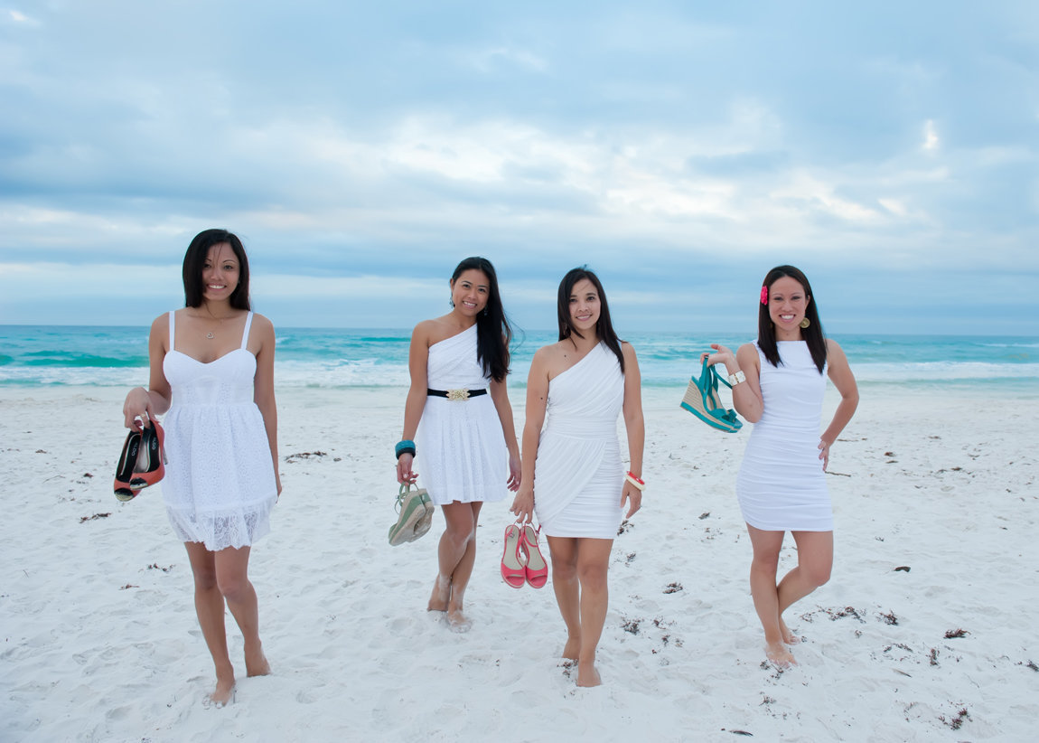 four friends walking on the beach with cute shoes in hand in Destin