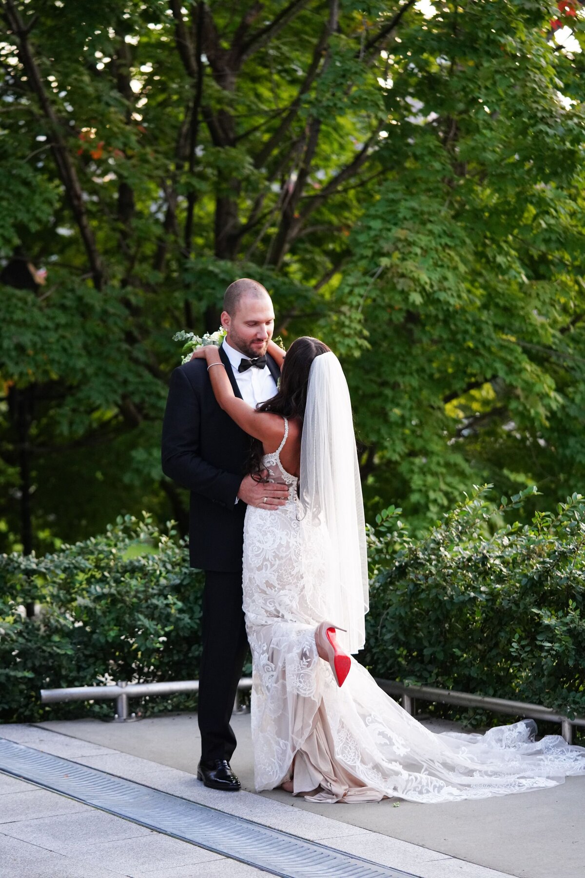 The bride and groom embrace each other with their arms wrapped around each other, standing face-to-face. Their expressions reflect a deep connection and affection, capturing a tender and intimate moment between them. The close-up shot highlights their love and the joy of their wedding day.