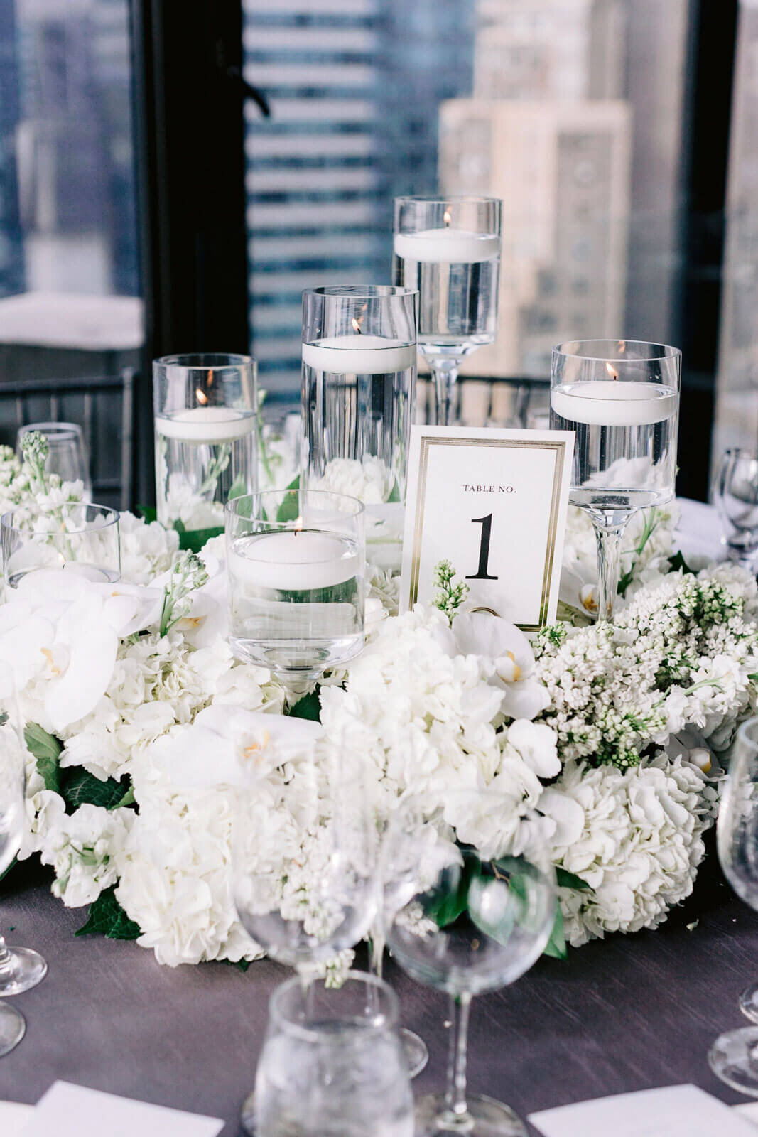 Table number one is filled with beautiful white flowers  in The Skylark, New York. Wedding Image by Jenny Fu Studio