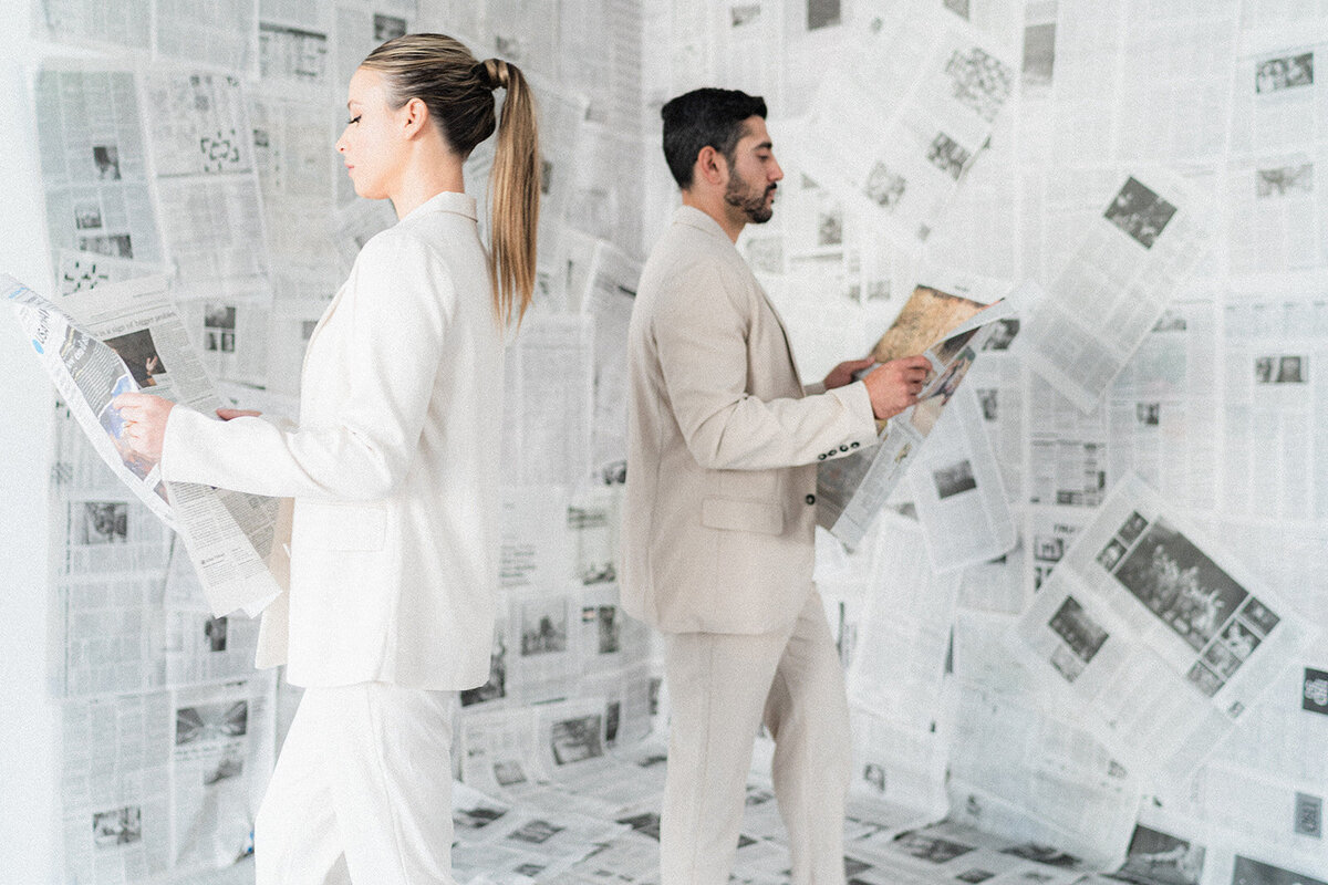 A couple walks with newspapers