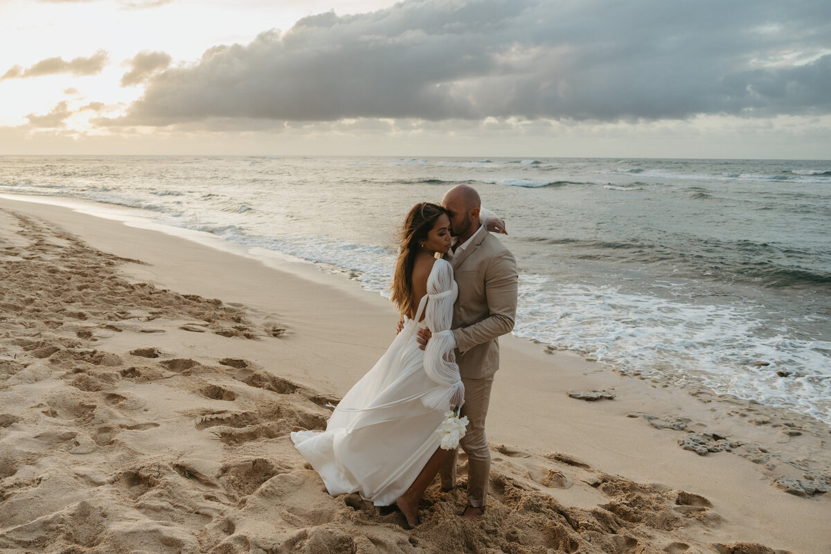 Bride and groom embracing on the beach