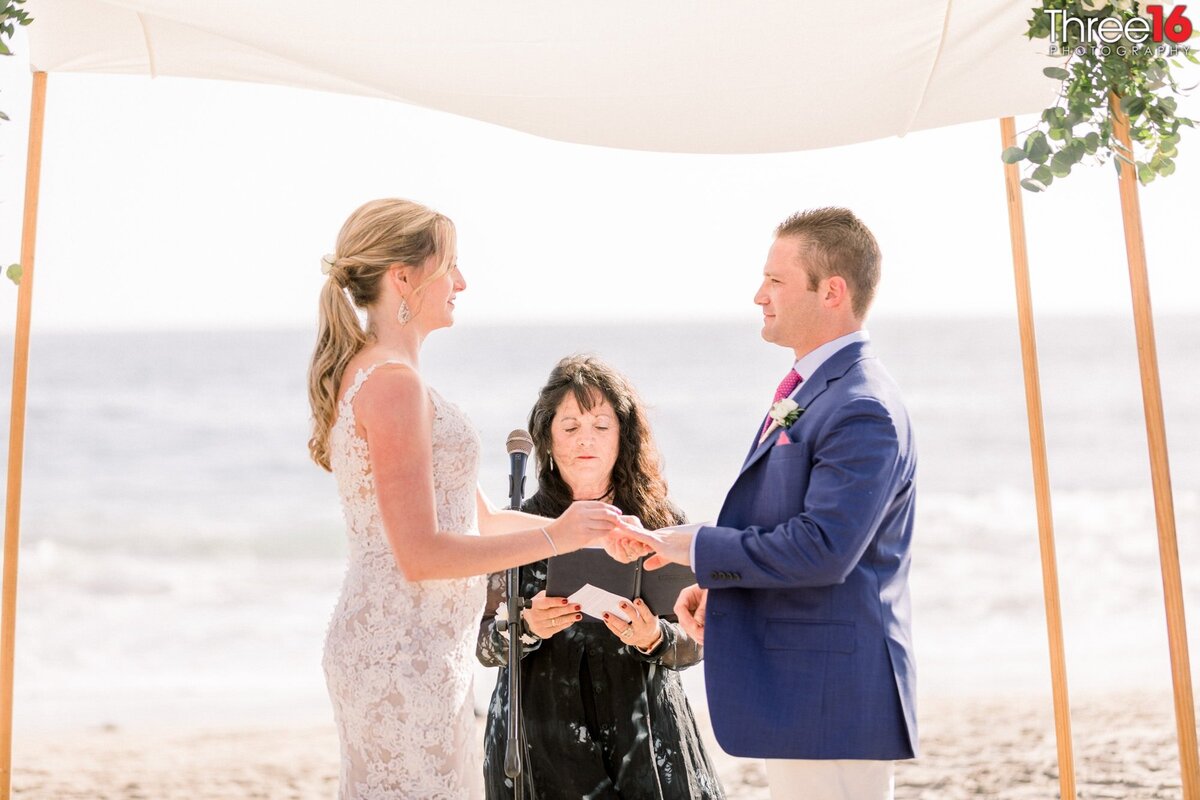 Bride and Groom face each other and hold hands during a Jewish wedding ceremony at the beach in Orange County