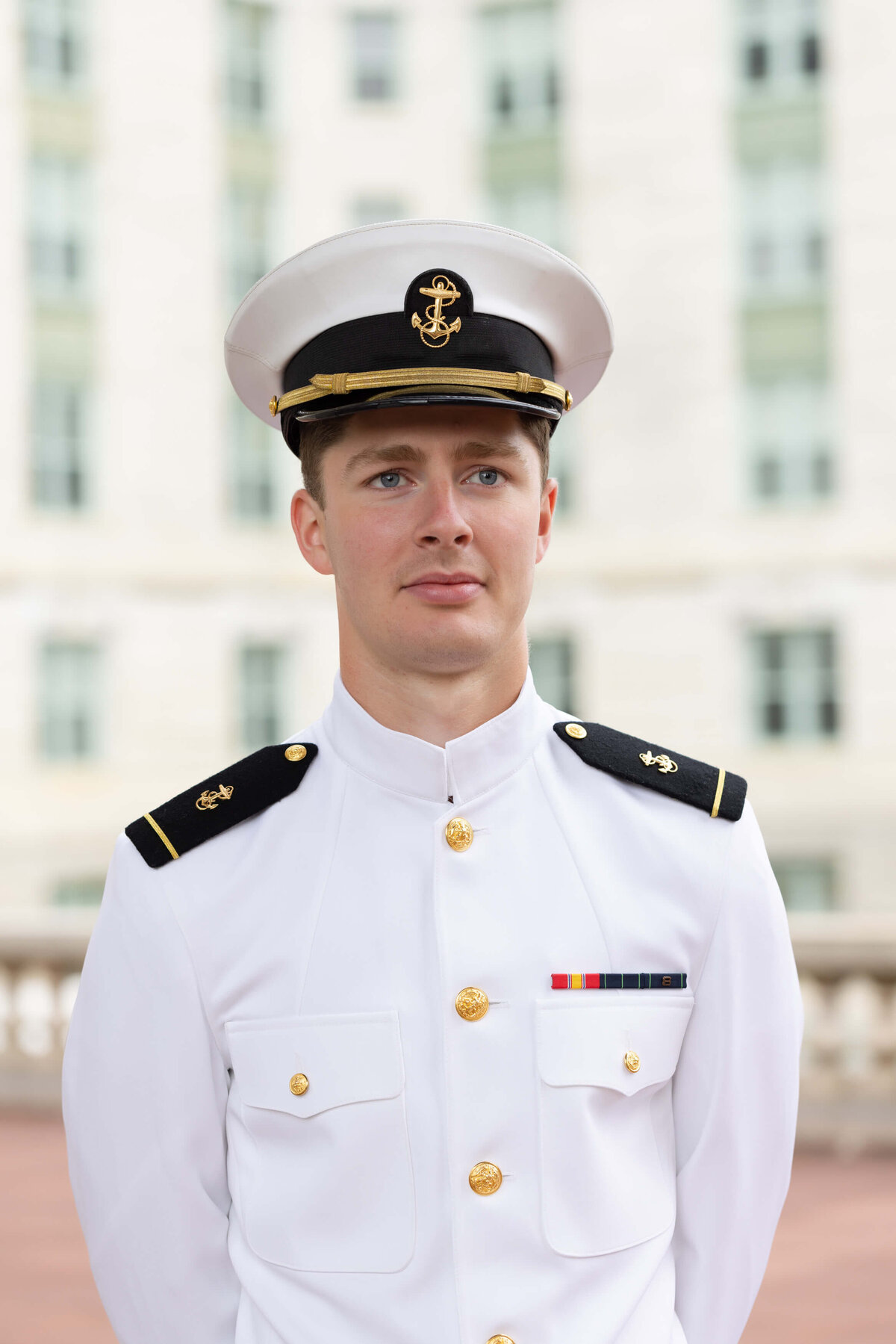 Senior Portrait in white uniform at Naval Academy.