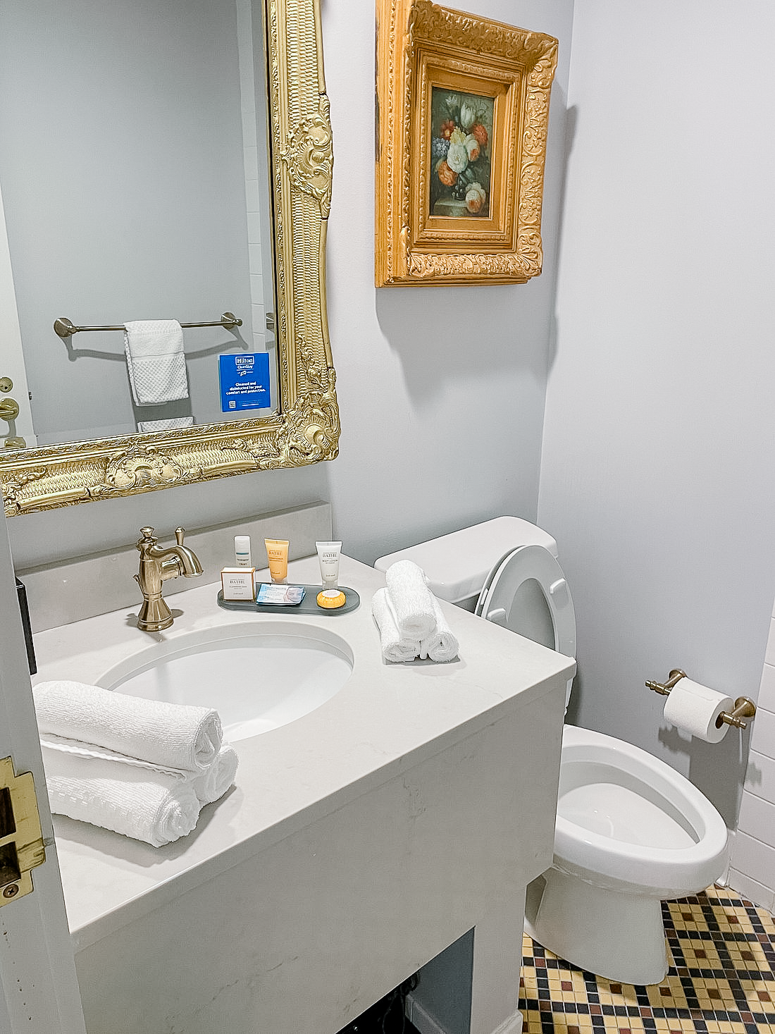 Boutique hotel guest bathroom with ornate mirror and faucet
