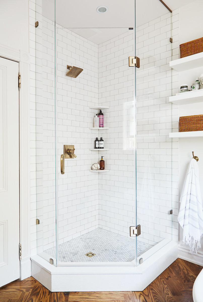 corner of white bathroom with custom shower and white subway tile