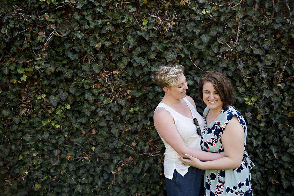 A couple with their arms around each other laughing 