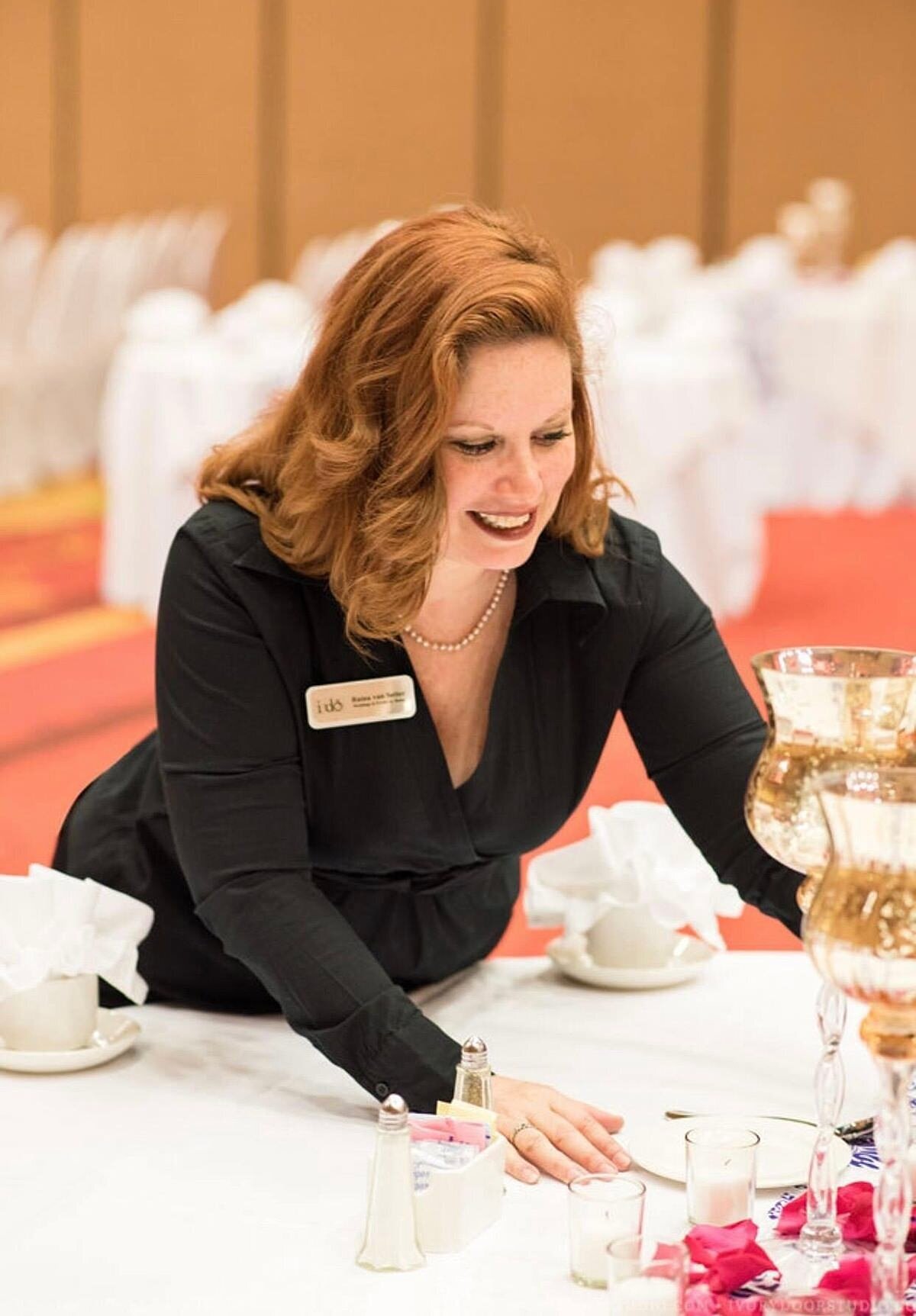 wedding planner adjusts the table centerpiece