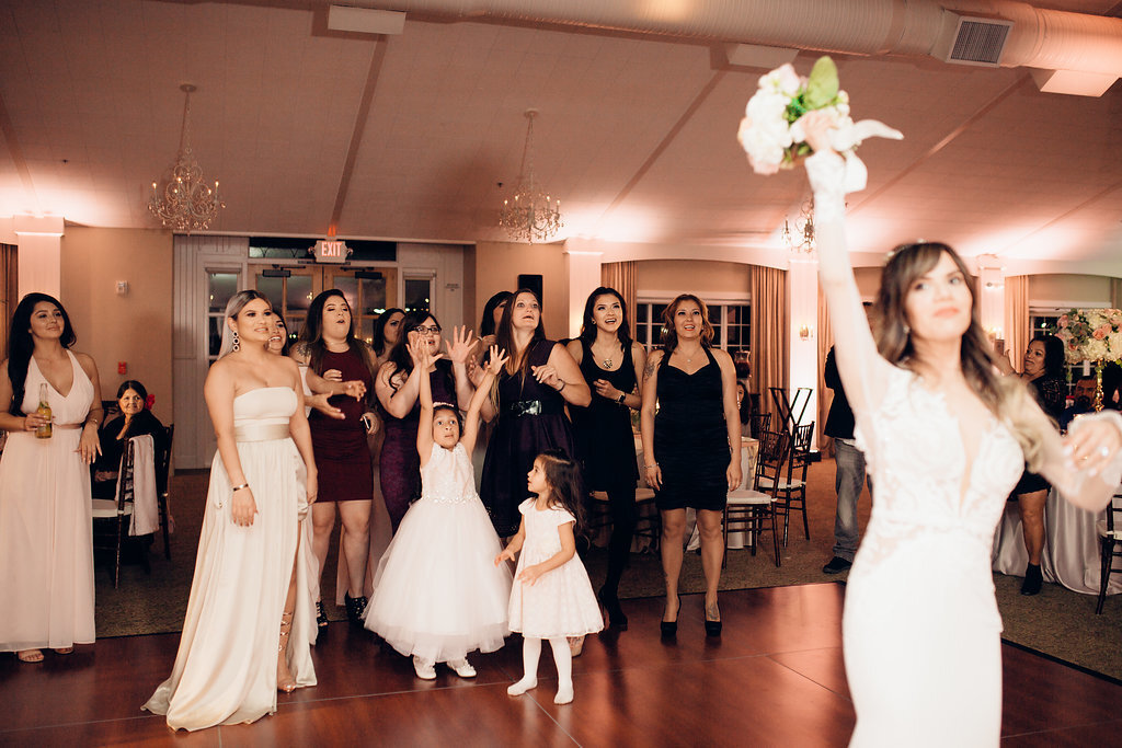 Wedding Photograph Of Women In White And Maroon Dresses Preparing To Catch The Bouquet Los Angeles