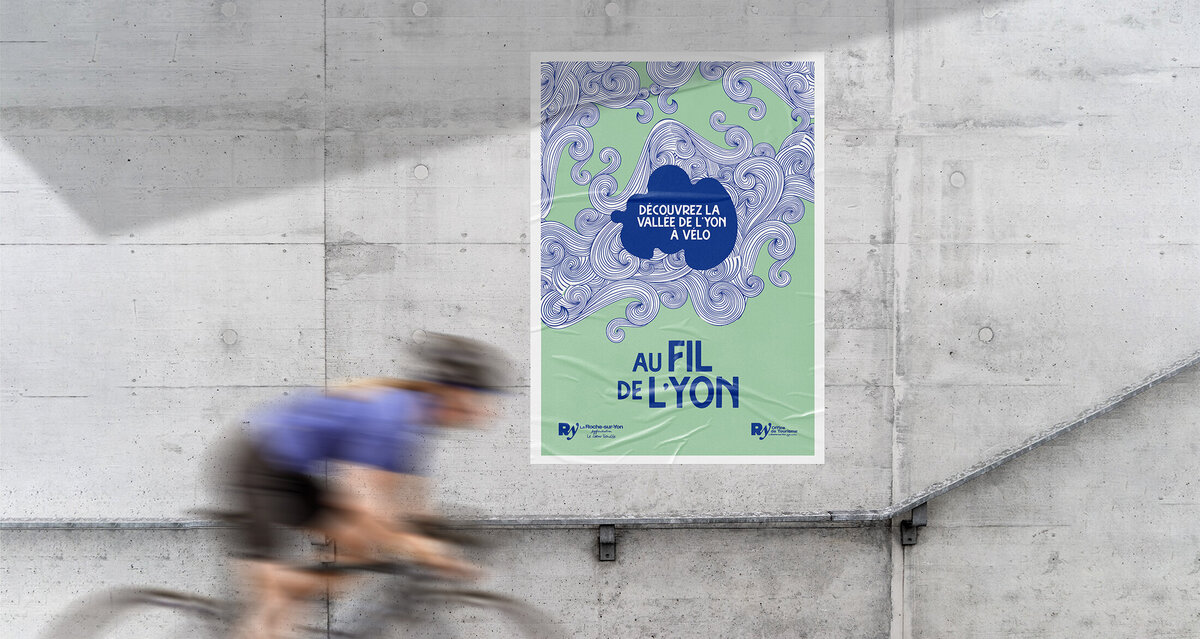 Affiche Au fil de l'Yon collée à un mur en béton. Cycliste en mouvement au premier plan dans un effet de flou. Crée par le STudio Youmé, pgrahiste à SAint-Gilles-Croix-de-Vie, Vendée.