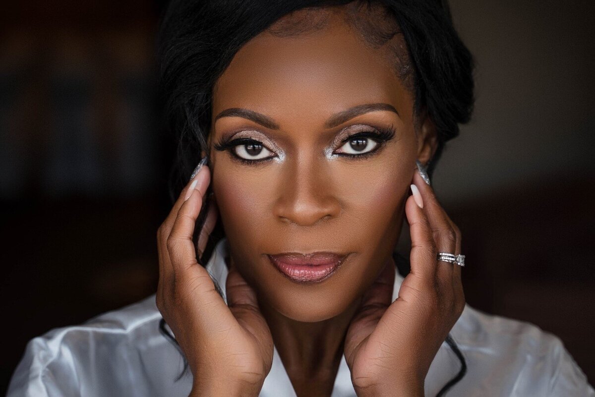 bride-soft-glam-look-holding-face-prep-photo-duneland-falls