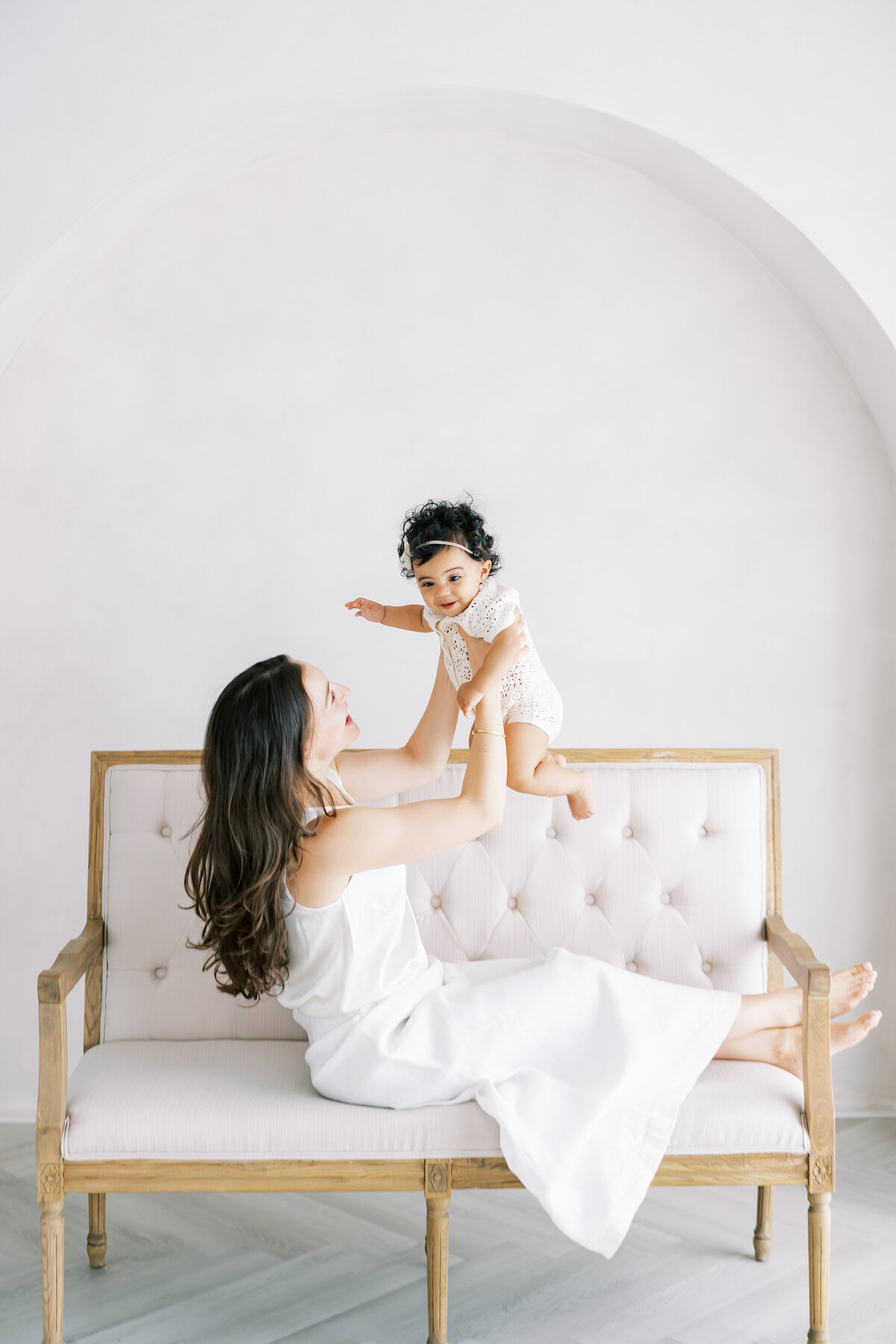 Mom holding a 6 months old baby during a studio phootshoot