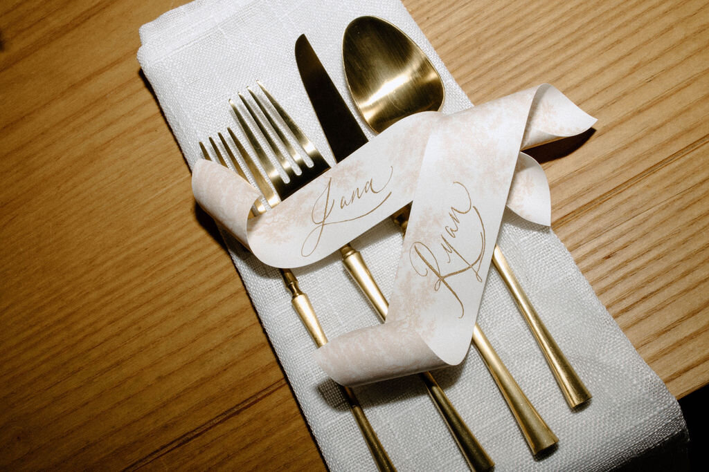 Elegant table setting with personalized napkin and gold flatware for a Bedford, NY family reunion dinner.