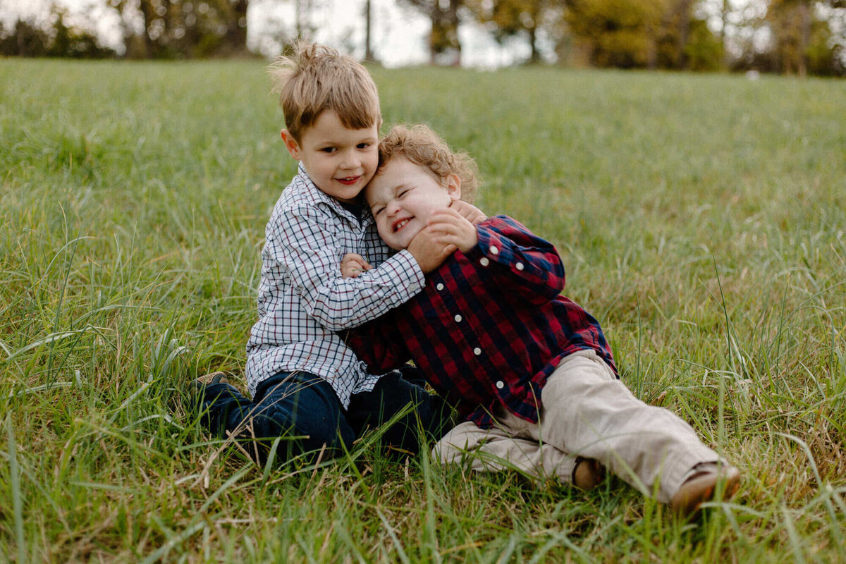 18-kara-loryn-photography-brothers-hugging-each-other-in-the-grass