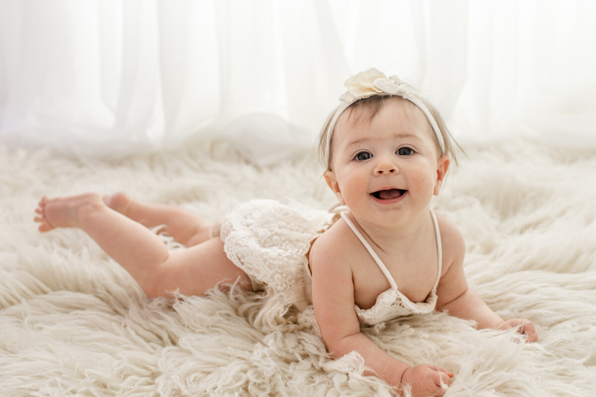 Little girl on her stomach, smiling at camera