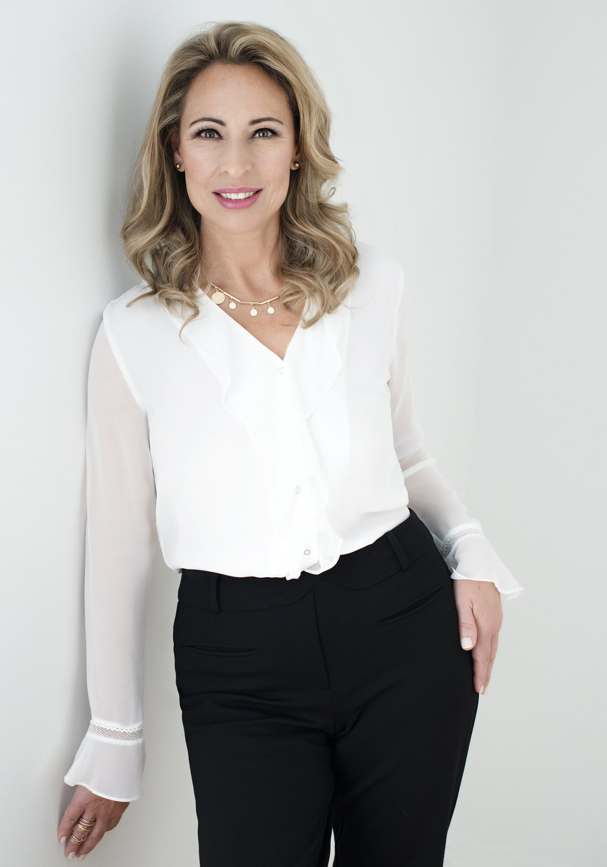 executive woman headshot very confdent  wearing white shirt and  black pants  crisp , professional business look in studio by puja misra