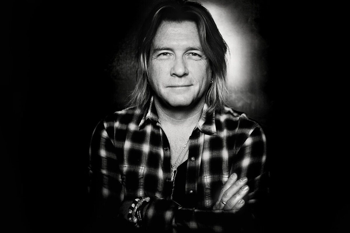 Bob Rock Musician Producer Portrait black and white arms folded across chest wearing plaid shirt