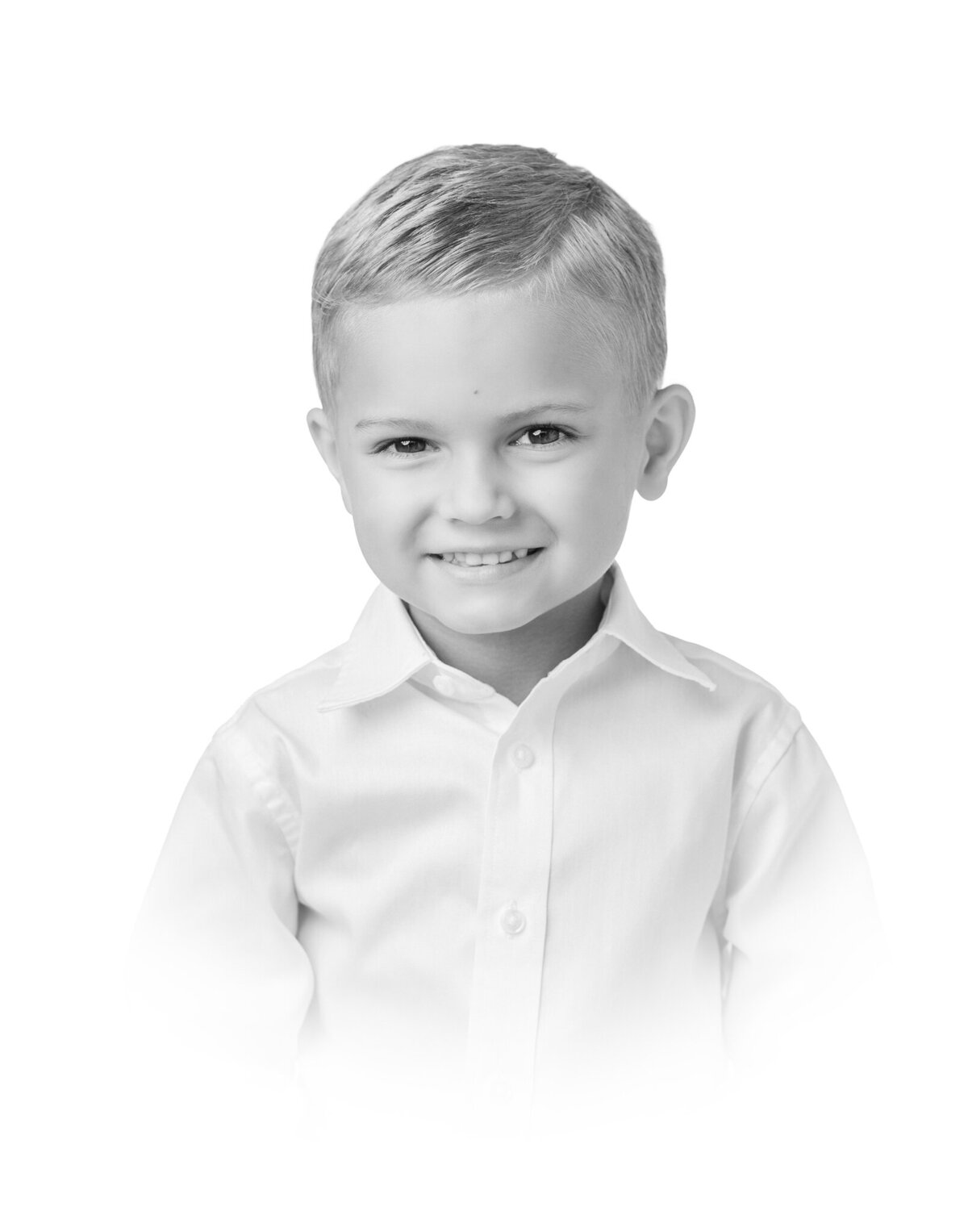 Black and white heirloom vignette of a young boy smiling in a white button down