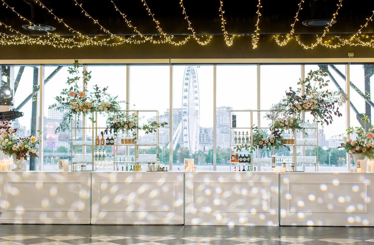 A bar at the Science Centre is elaborately decorated with elegant wedding flowers.
