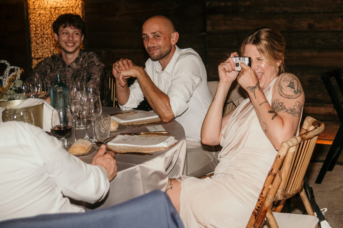 Wedding party photography of the bridesmaid taking a picture with a disposable camera. 