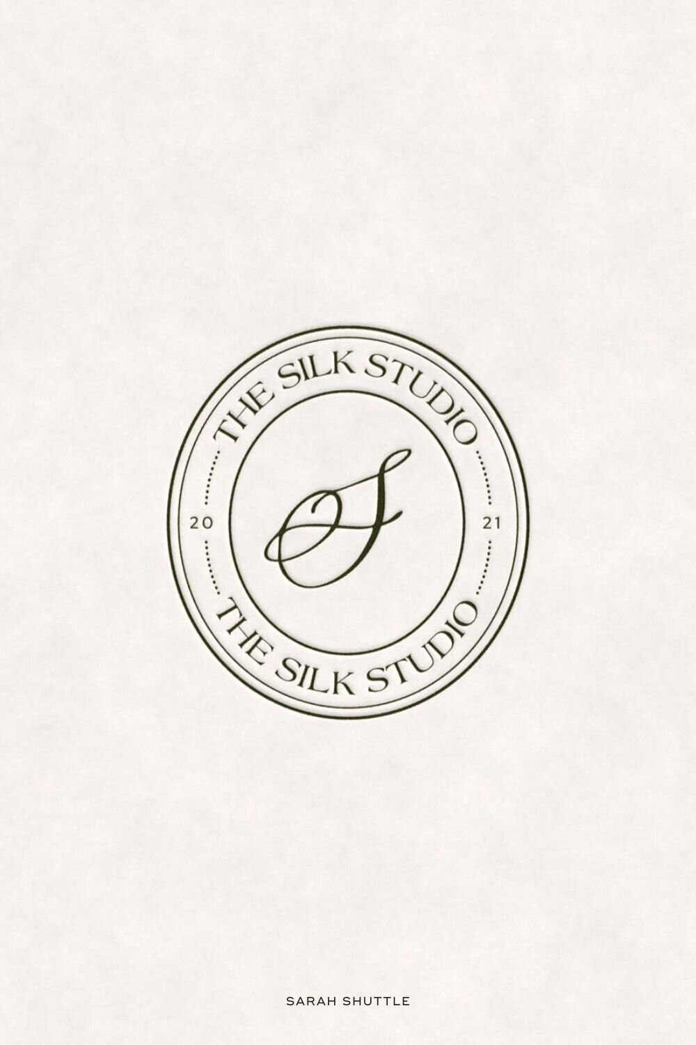 Oval brand submark for The Silk Studio printed on textured white paper for a refined, luxurious feel