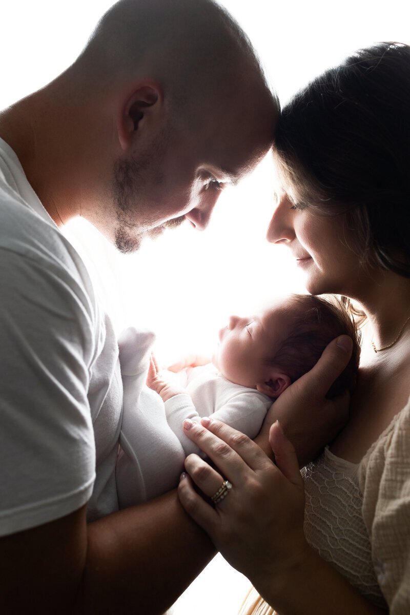 Parents holding and looking at newborn baby taken by new jersey photographer Ally Kimpton Photography